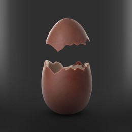 Image of Broken milk chocolate egg on black background