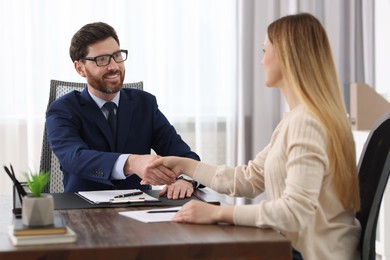 Photo of Lawyer shaking hands with client in office, selective focus