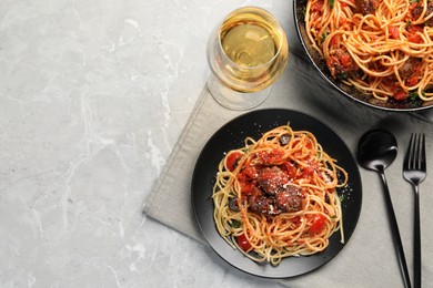 Photo of Delicious pasta with meatballs and tomato sauce served on light grey table, flat lay. Space for text