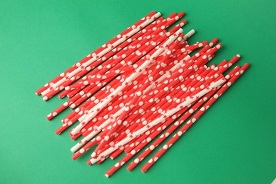 Photo of Many paper drinking straws on green background, top view