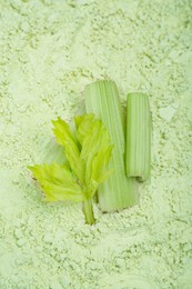 Fresh stalks on natural celery powder, above view