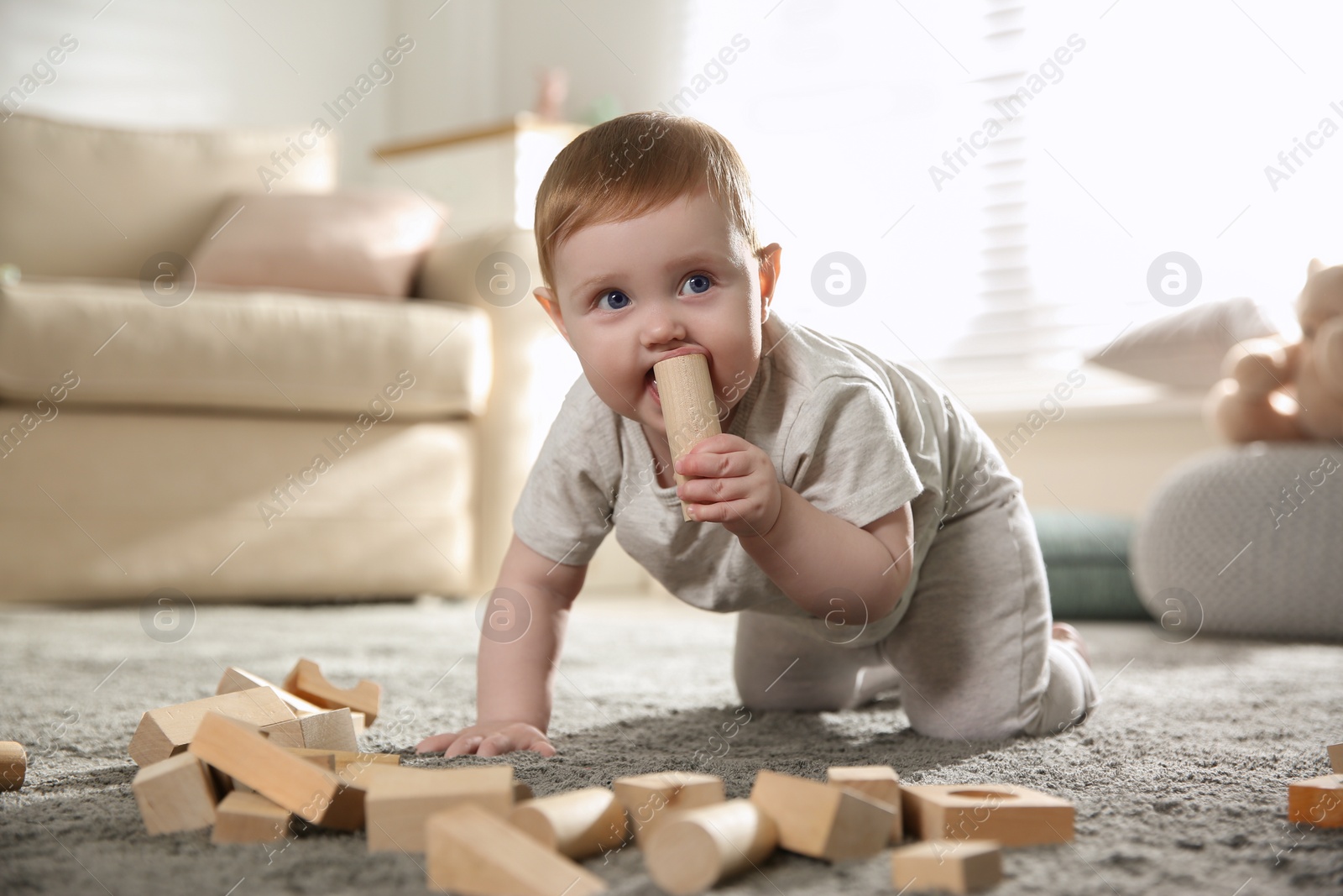 Photo of Cute baby playing with wooden blocks at home