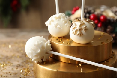 Photo of Delicious Christmas ball cake pops on wooden table, closeup