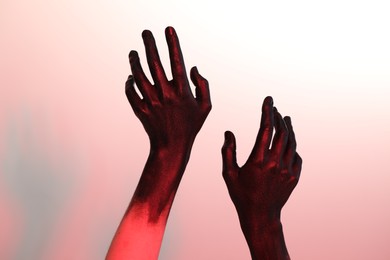 Woman with hands painted in black color on white background, closeup