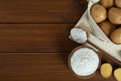 Starch and fresh raw potatoes on wooden table, flat lay. Space for text