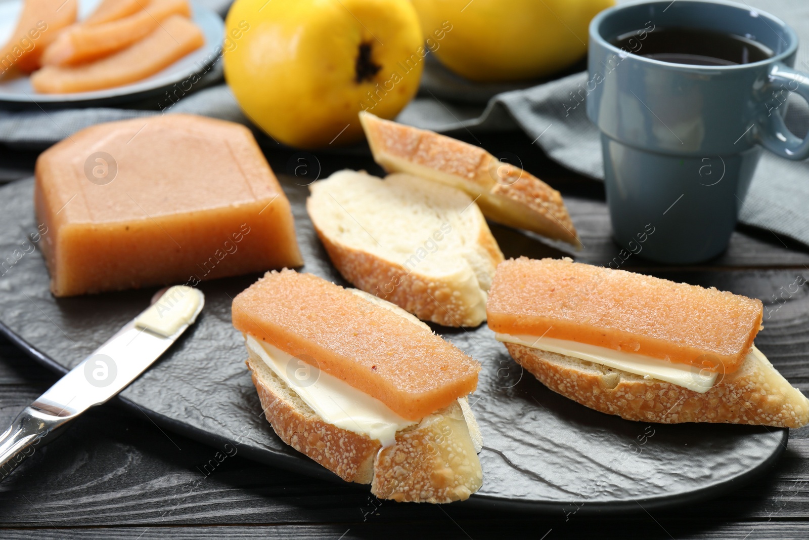 Photo of Tasty sandwiches with quince paste served on black wooden table, closeup