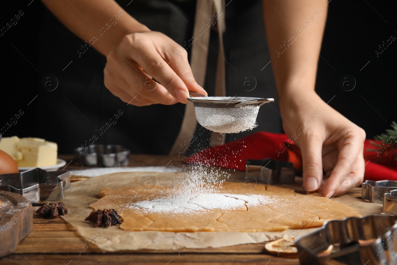 Photo of Woman making Christmas cookies at wooden table, closeup