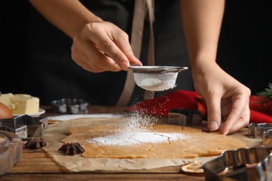 Photo of Woman making Christmas cookies at wooden table, closeup