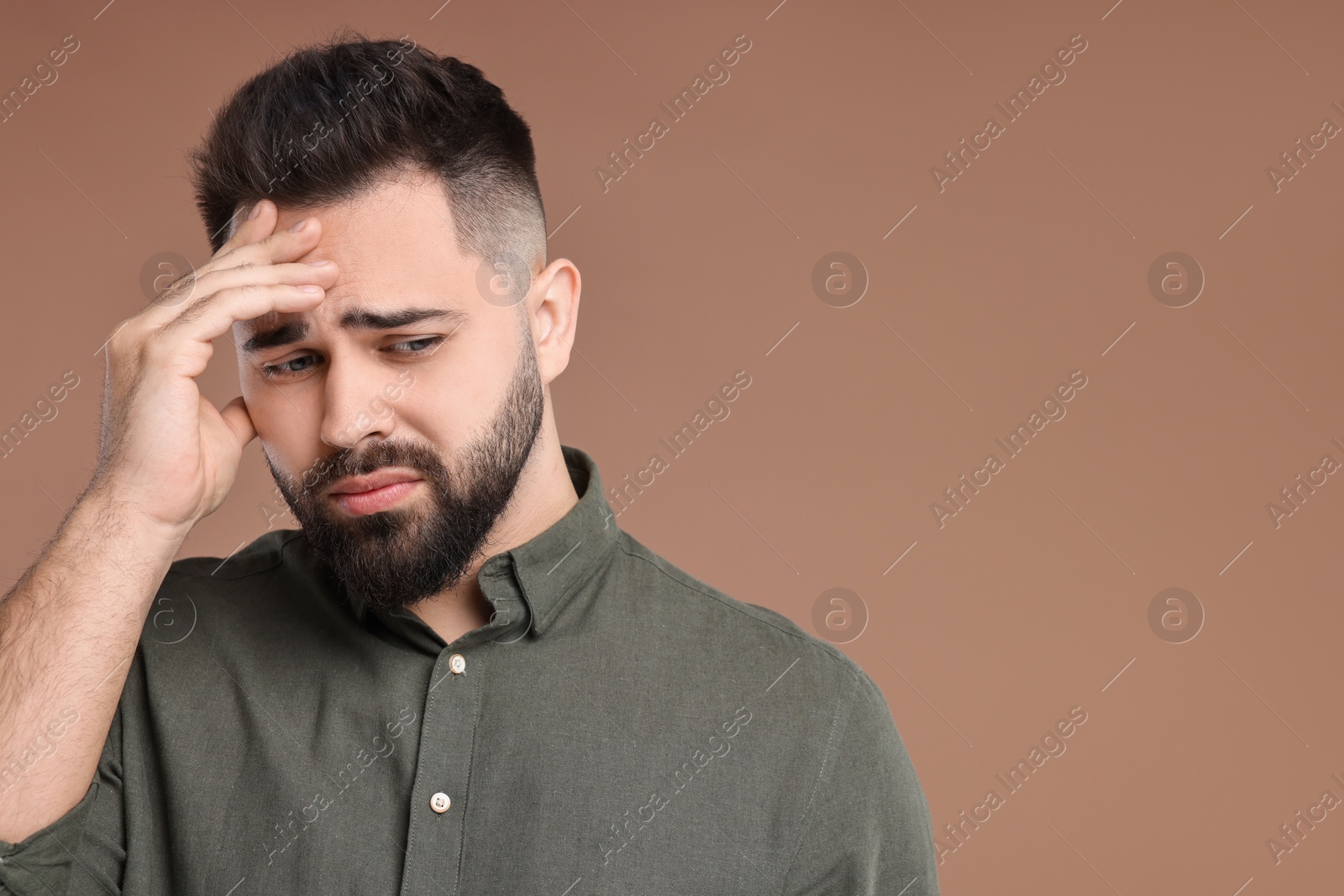 Photo of Portrait of sad man on brown background, space for text