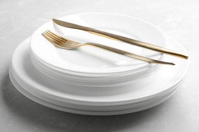 Photo of Stack of plates with fork and knife on table