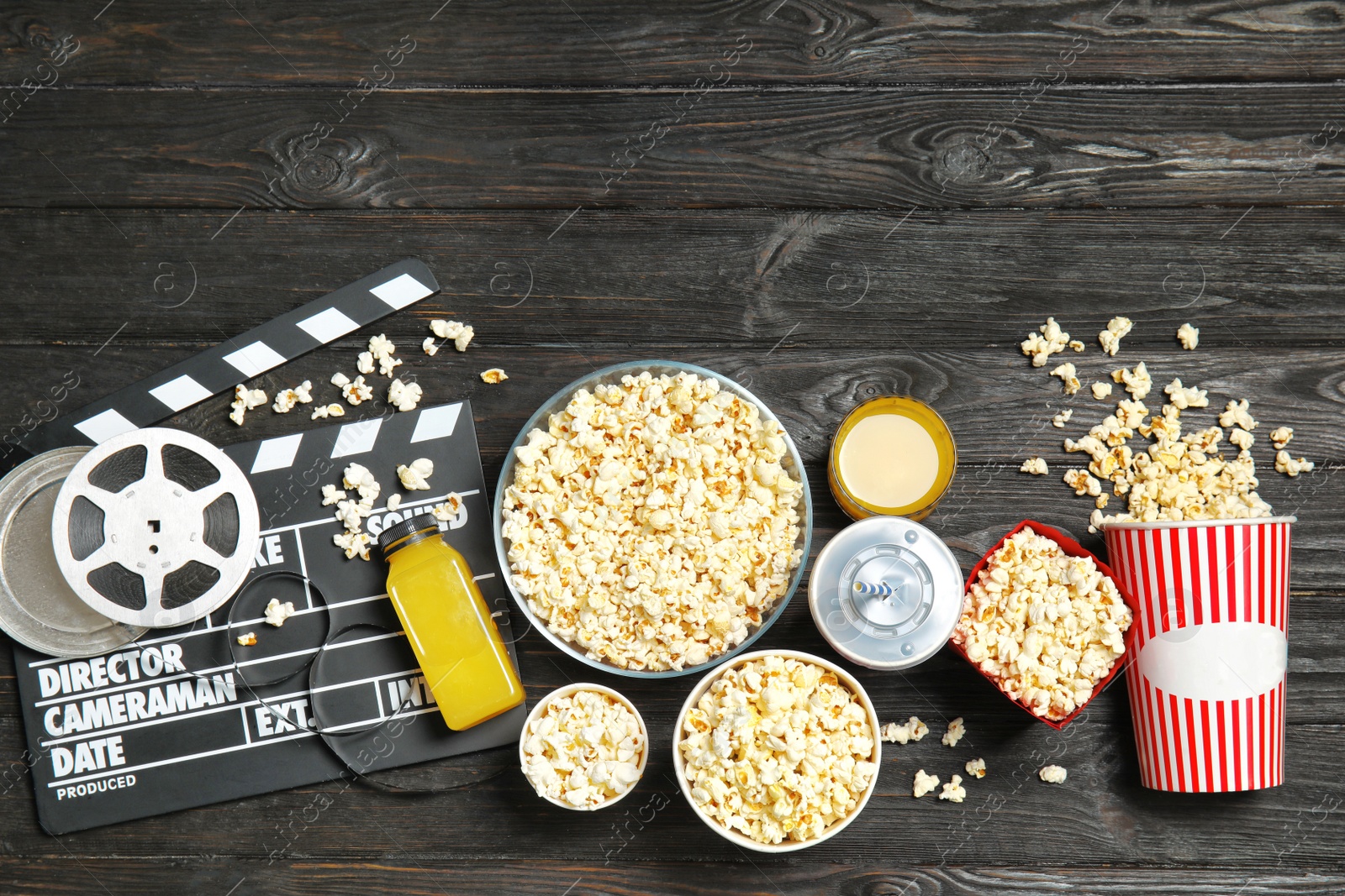 Photo of Flat lay composition with popcorn, cinema clapperboard and space for text on wooden background