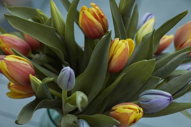 Photo of Beautiful bouquet of colorful tulips on color background, closeup view