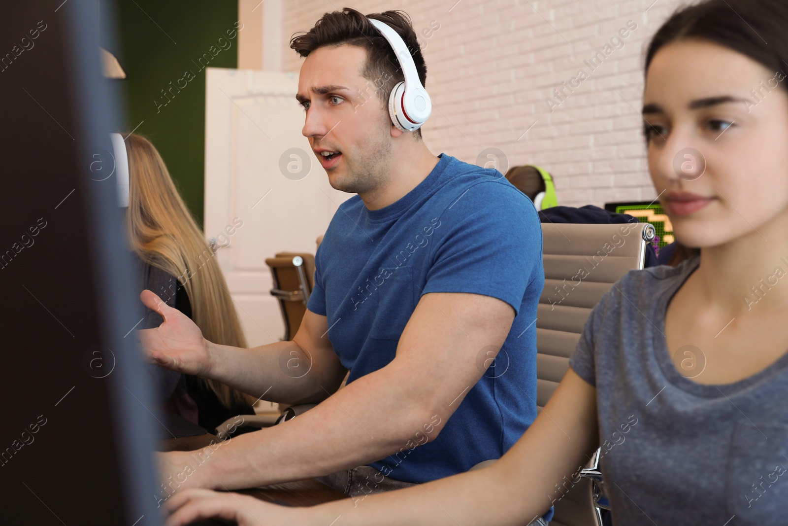 Photo of Young people playing video games on computers indoors. Esports tournament