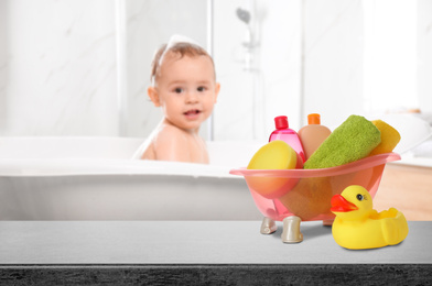 Image of Baby cosmetic products, toy and bathing accessories on table in bathroom