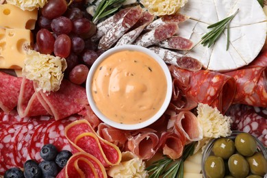 Photo of Different delicious snacks and sauce, top view