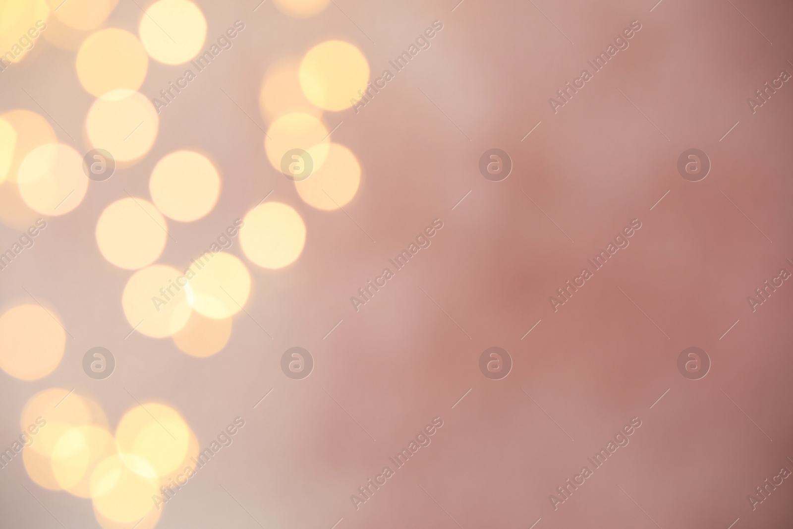 Photo of Blurred view of gold lights on pink background, bokeh effect. Space for text