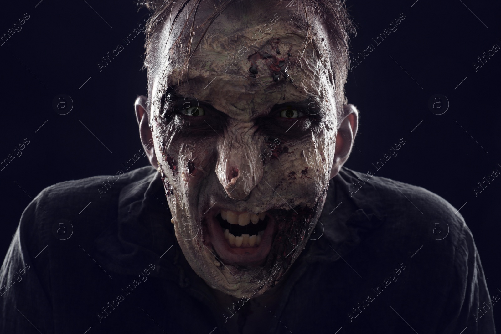 Photo of Scary zombie on dark background, closeup. Halloween monster