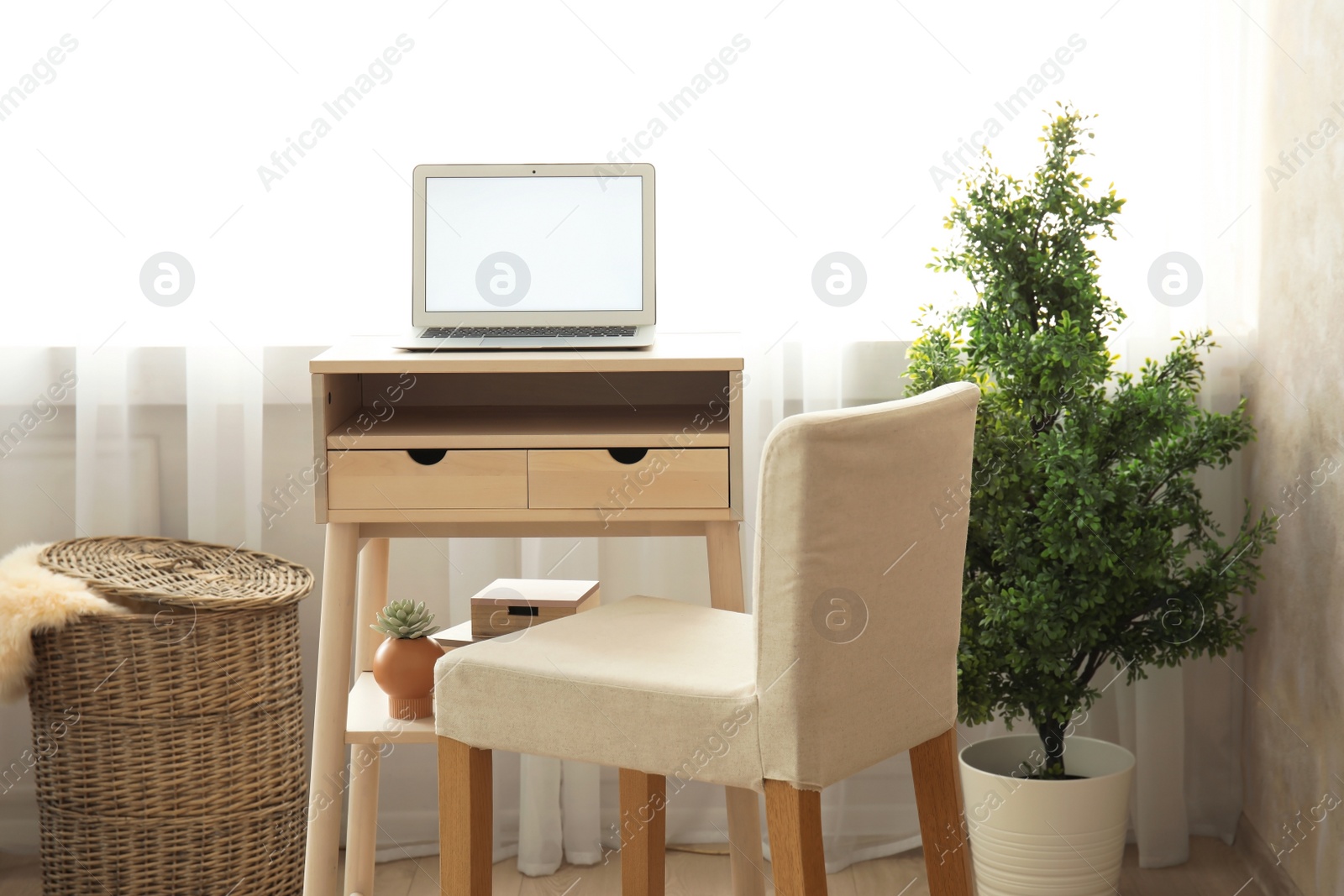 Photo of High wooden table with laptop as stand up workplace in modern interior