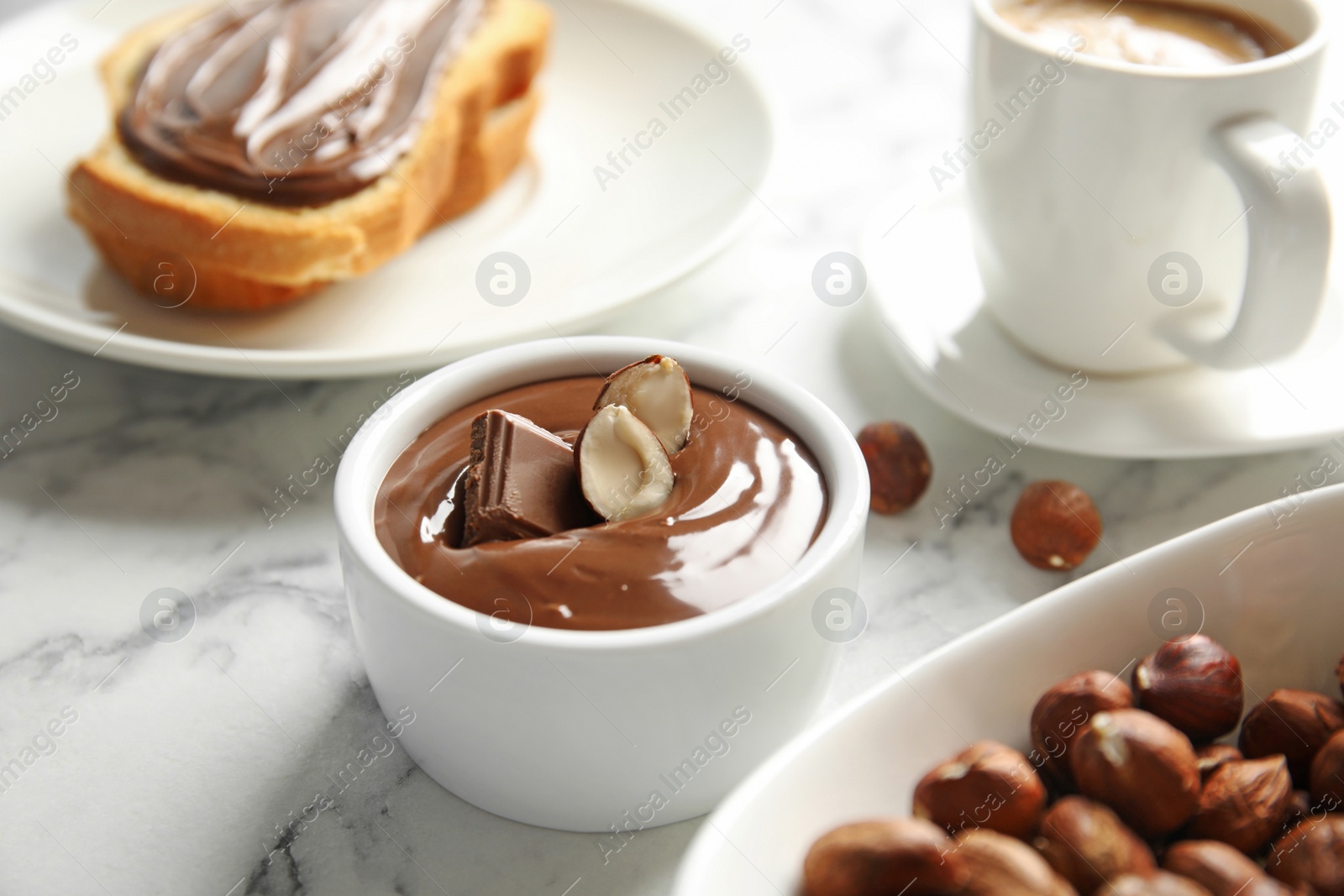 Photo of Sweet chocolate mousse with hazelnuts served on marble table