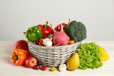 Assortment of fresh vegetables and fruits on white wooden table