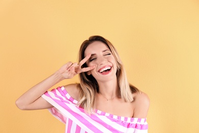 Portrait of beautiful laughing woman on color background