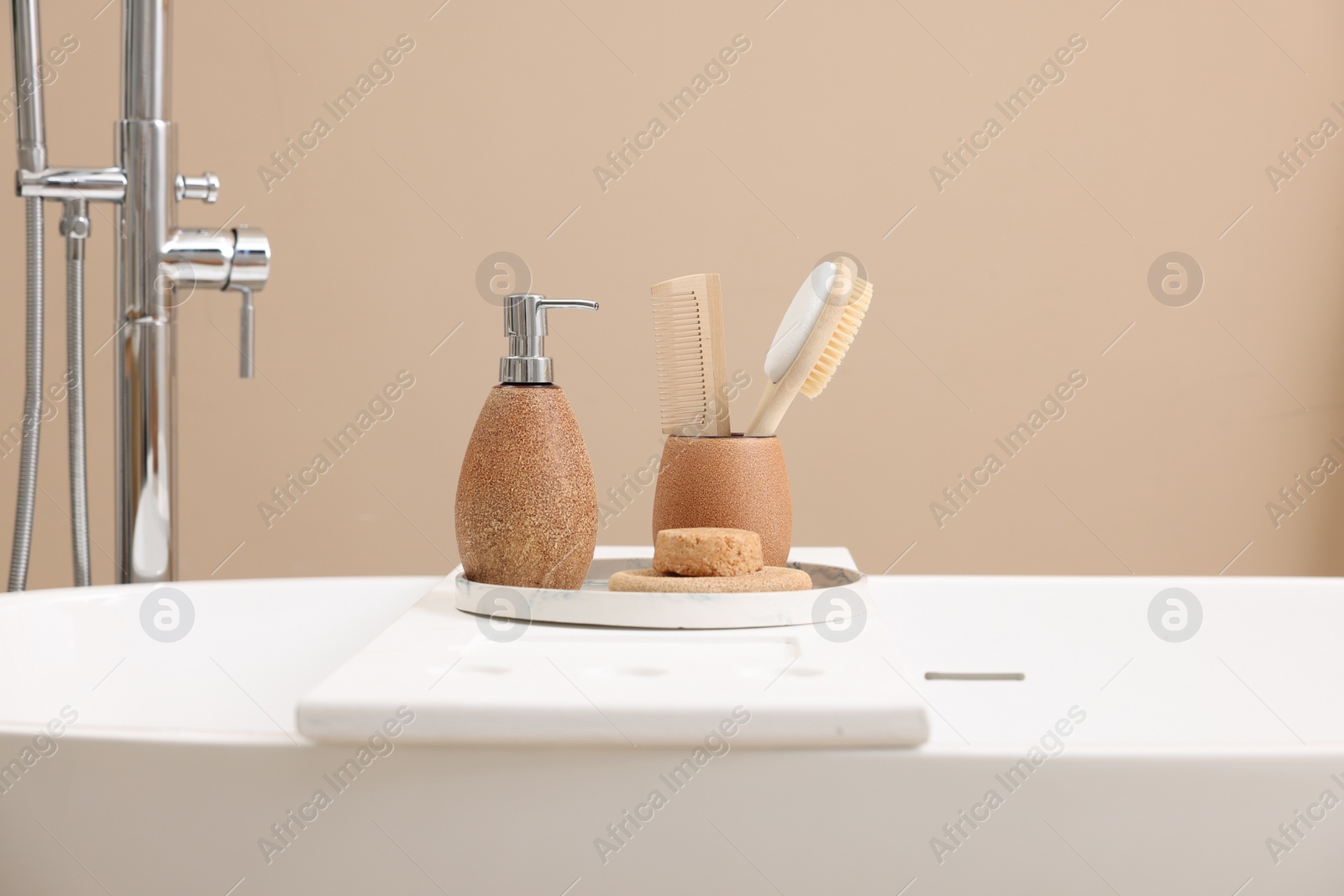 Photo of Different personal care products and accessories on bath tub in bathroom