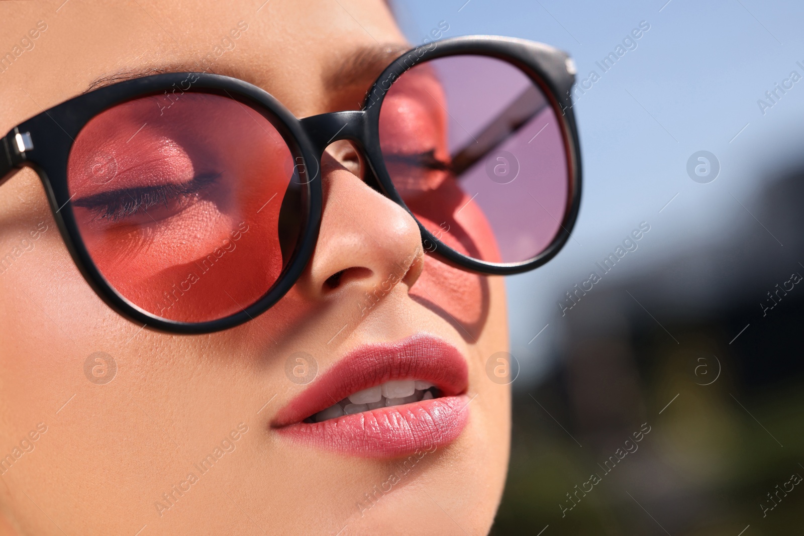 Photo of Beautiful woman in sunglasses outdoors, closeup. Space for text