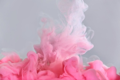 Photo of Splash of pink ink on grey background