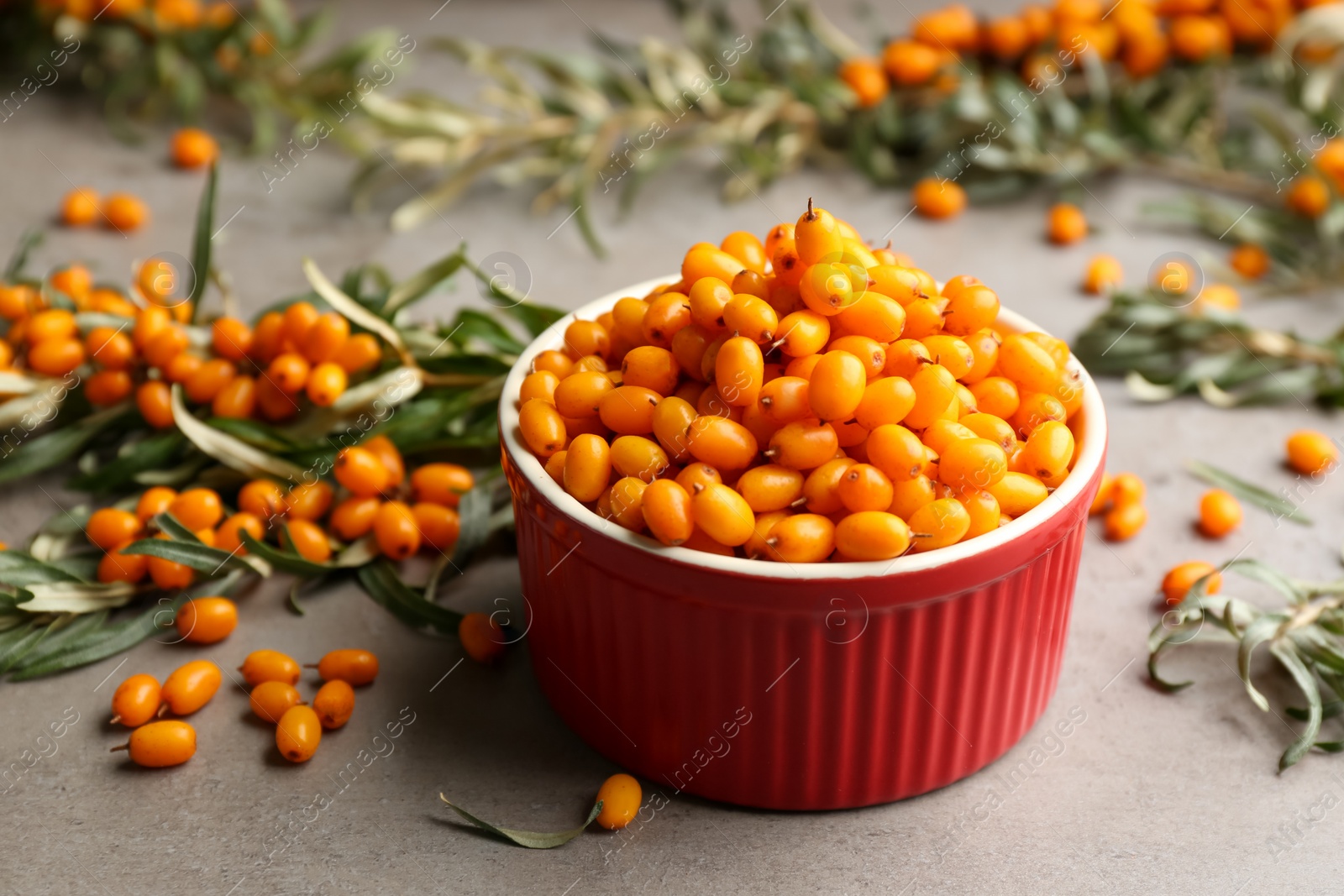 Photo of Fresh ripe sea buckthorn in bowl on grey table