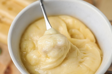 Dipping bread into delicious cheese fondue, closeup