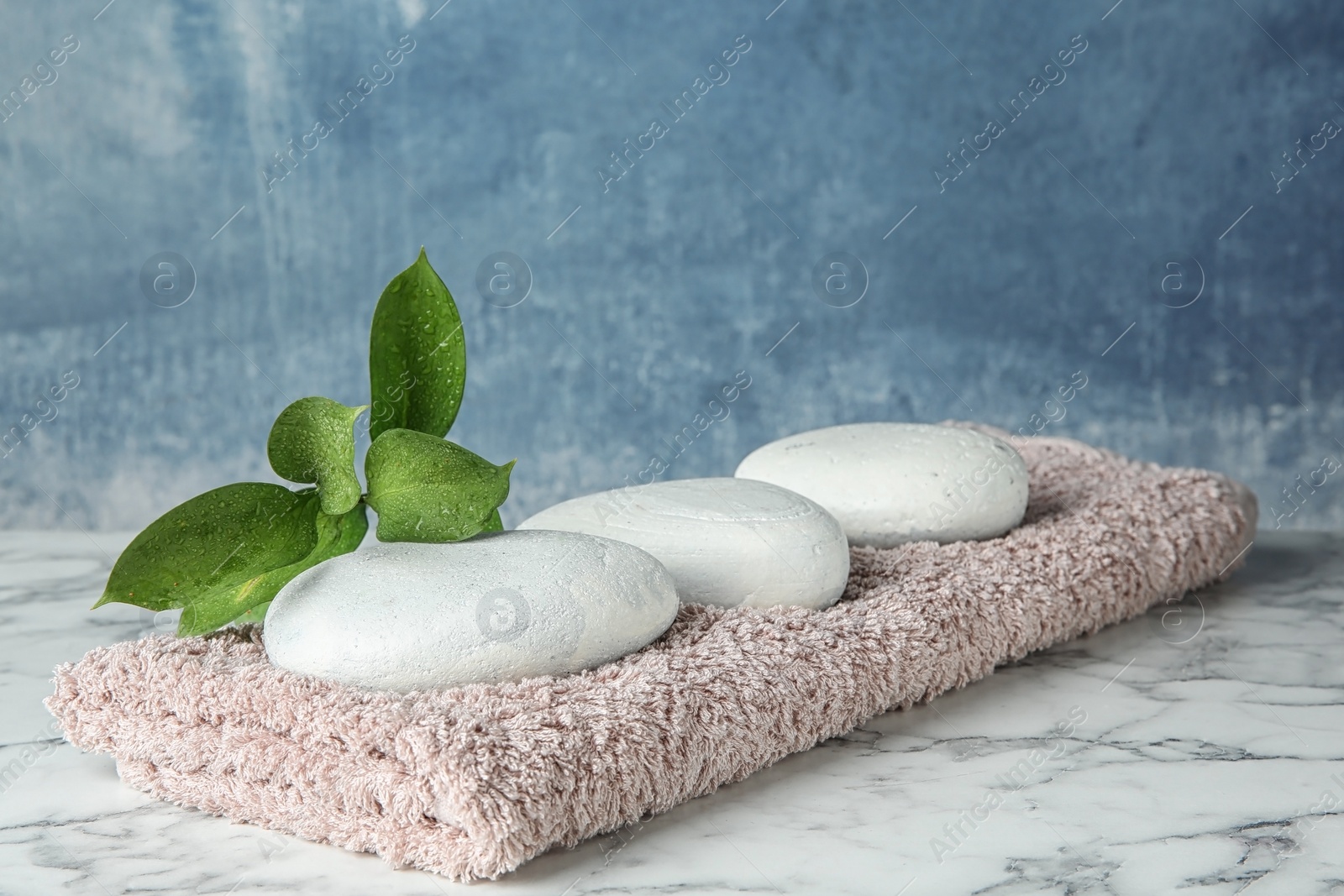 Photo of Beautiful composition with spa stones and towel on table