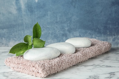 Photo of Beautiful composition with spa stones and towel on table