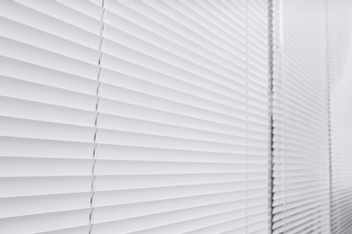 Window with closed white horizontal blinds as background