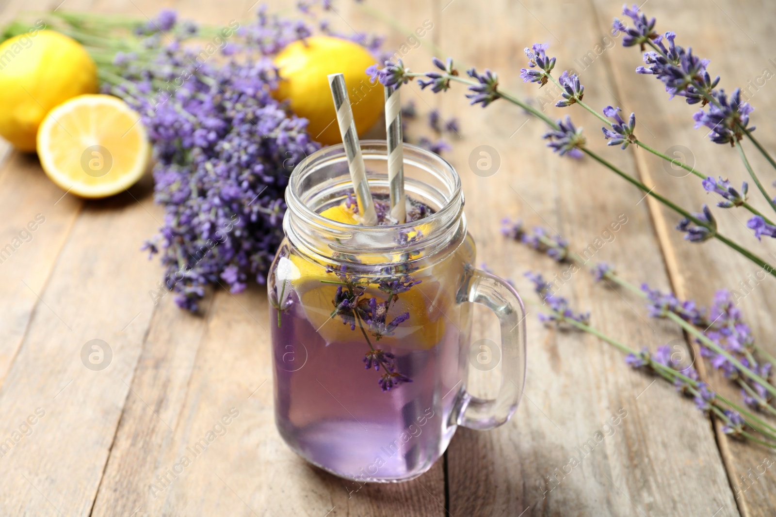 Photo of Fresh delicious lemonade with lavender in masson jar on wooden table