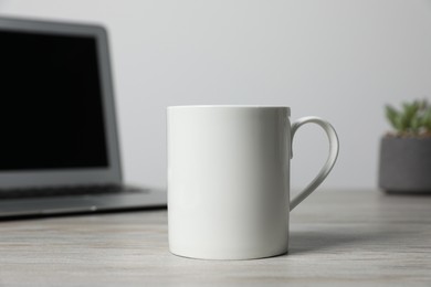 Photo of One ceramic mug on white wooden table