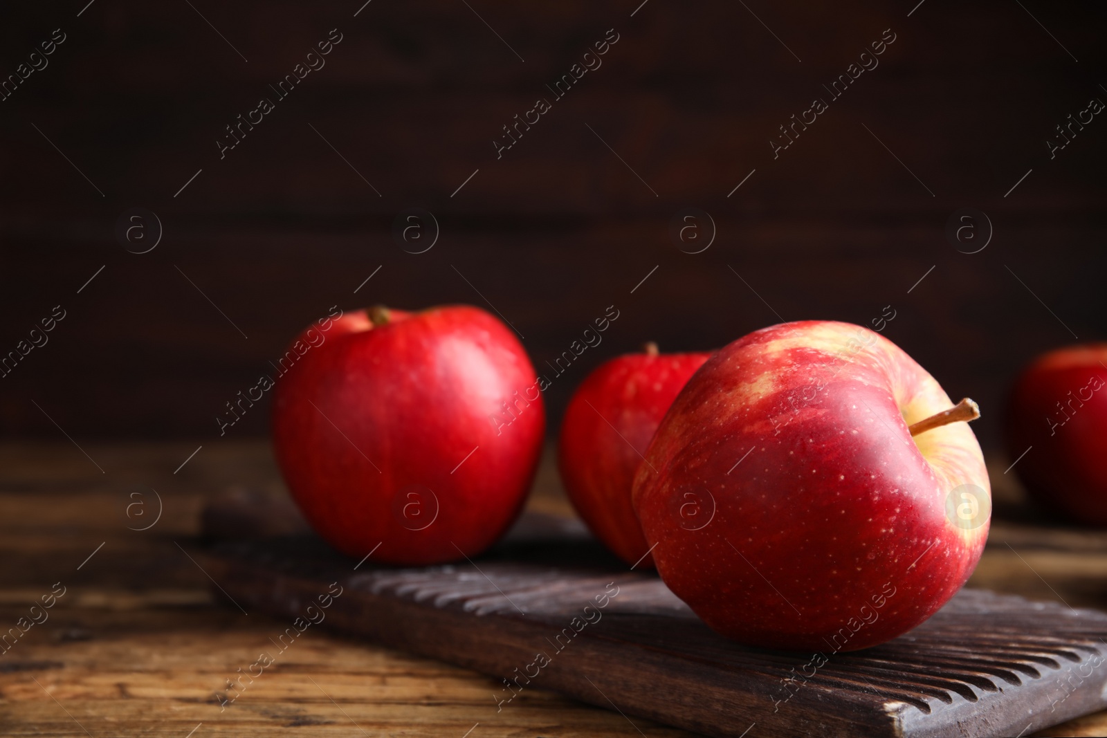 Photo of Fresh ripe red apples on wooden table. Space for text