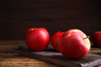 Photo of Fresh ripe red apples on wooden table. Space for text