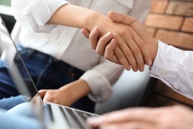 Business partners shaking hands after meeting, closeup