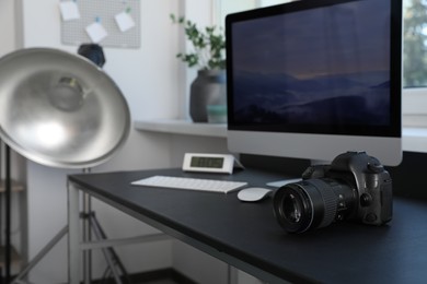 Photo of Professional camera and computer on table in photo studio. Interior design