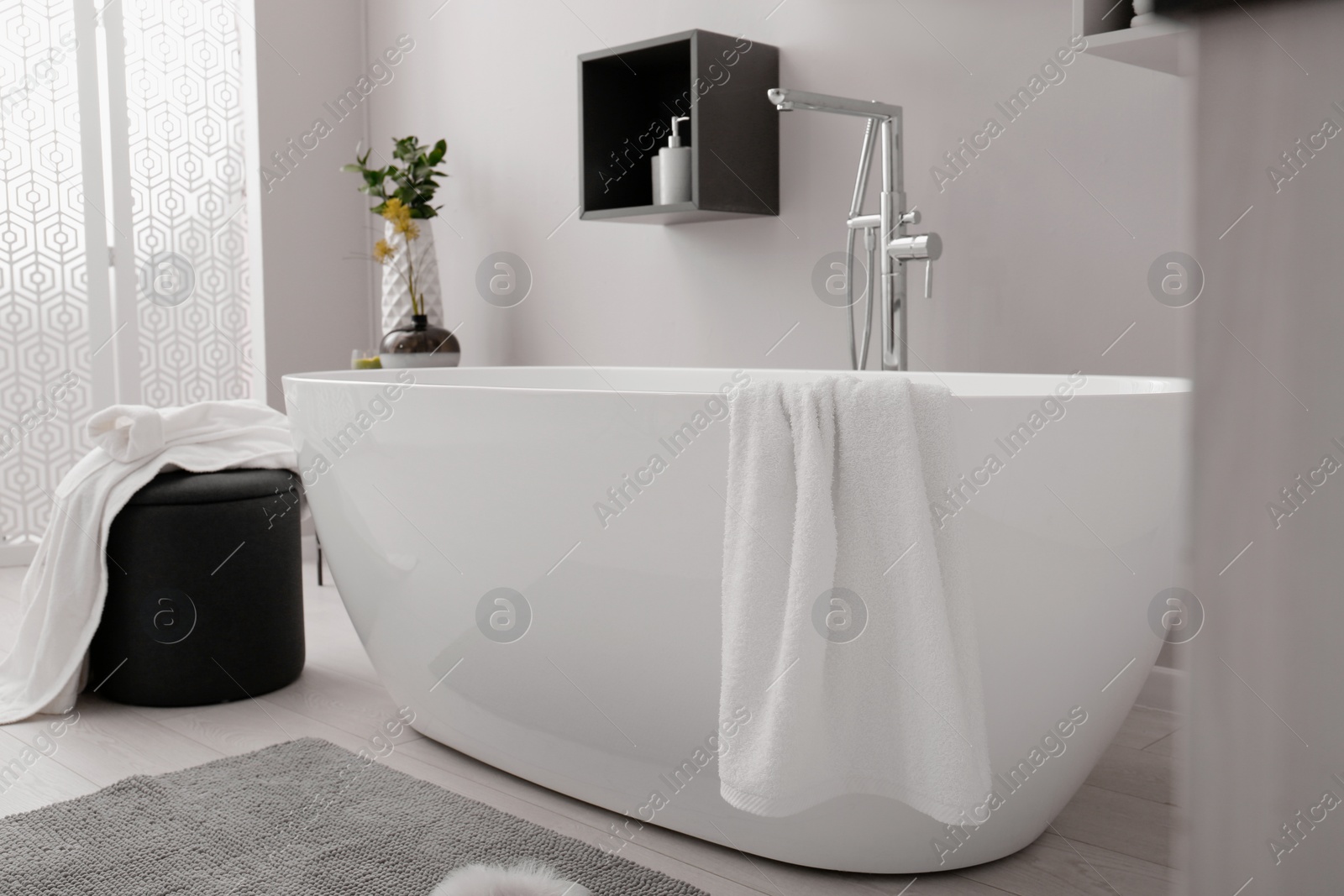 Photo of Stylish bathroom interior with modern white tub