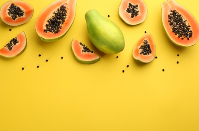 Photo of Fresh ripe papaya fruits on yellow background, flat lay. Space for text