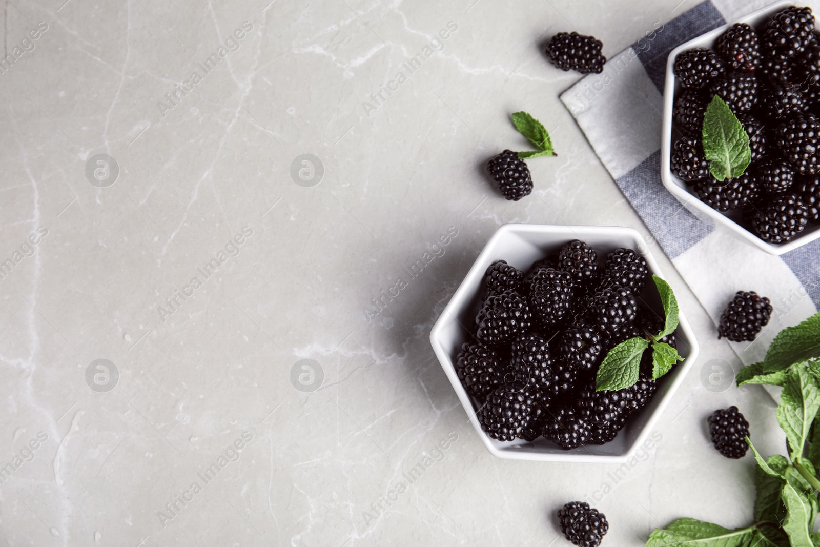 Photo of Flat lay composition with tasty blackberries and space for text on grey marble table