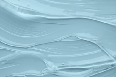 Clear cosmetic gel on light blue background, top view