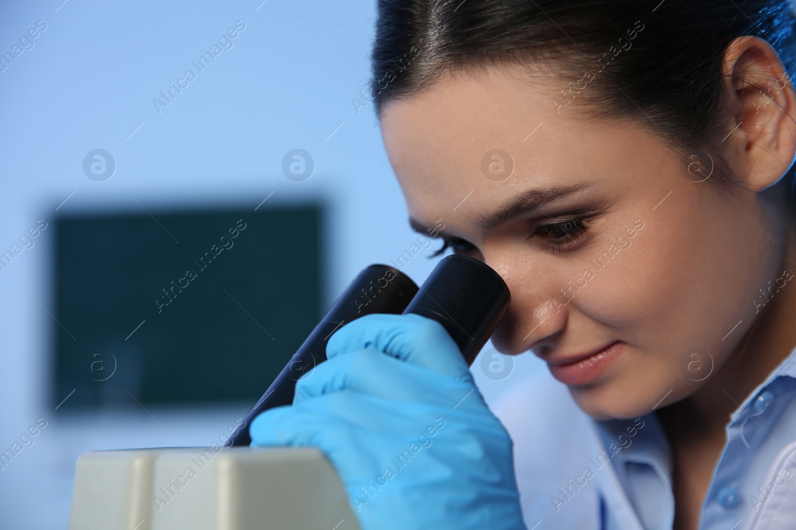 Photo of Female scientist using microscope in chemistry laboratory, space for text