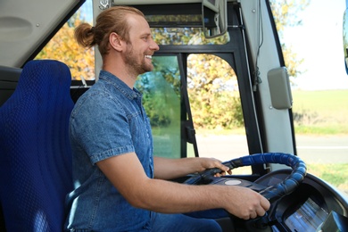 Photo of Professional bus driver at steering wheel. Passenger transportation