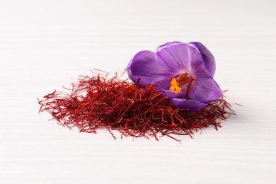 Dried saffron and crocus flower on white wooden table