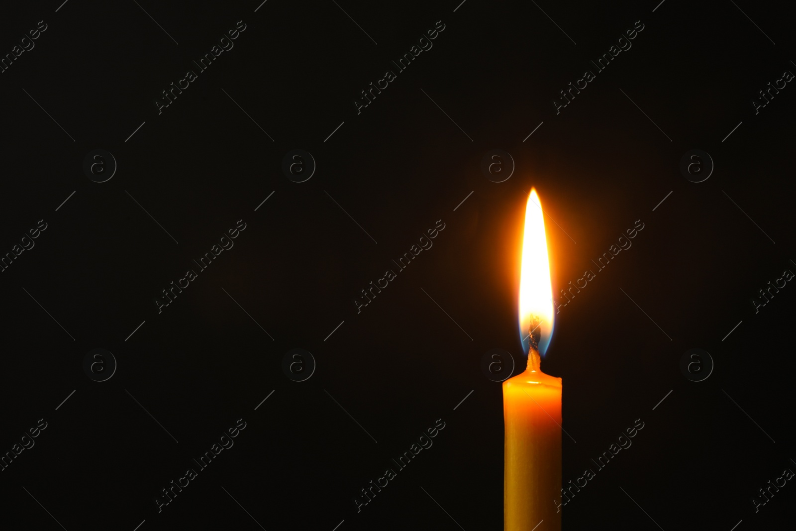 Photo of Burning candle on dark background, space for text. Symbol of sorrow