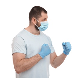 Photo of Man with protective mask and gloves in fighting pose on white background. Strong immunity concept