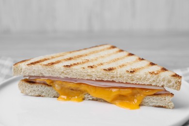 Photo of Delicious grilled sandwich with ham and cheese on plate, closeup
