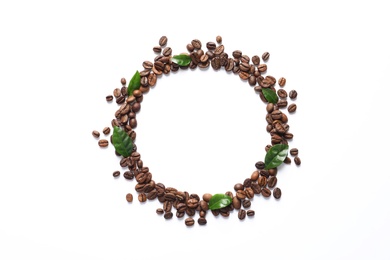 Frame made of fresh green coffee leaves and beans on white background, top view. Space for text